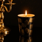 Bougie luxe Porcelaine de Limoges noire et or, décor carrés, allumée sur fond tamisé