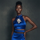 Collier Lorena en platine, bijou de créateur porté par femme en robe bleue satinée élégante