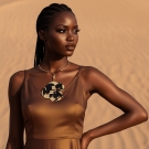 Collier Perlia en or et noir Lorenza Di Filippo, création de luxe portée avec robe bronze