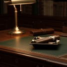 Cendrier Byzance en porcelaine noire posé sur un bureau avec cigares