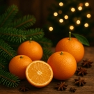 Oranges entières et coupées entourées de branches de sapin et d’anis étoilé, bougie Last Christmas