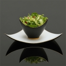 Présentation d’une salade dans la coupe et l’assiette Shérazade en porcelaine de luxe noire et blanche, filet or