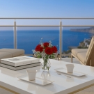 Café des Délices blanc et or sur terrasse face à la mer, bouquet de roses rouges