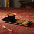 Tasse à café Café des Délices noir et or avec biscuits sur nappe rouge brodée