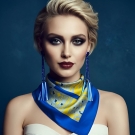 Portrait studio d’une femme portant le carré de soie Anissa bleu et jaune Lorenza Di Filippo, noué élégamment autour du cou.