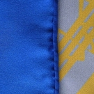 Gros plan sur le roulotté main du carré de soie Anissa bleu et jaune Lorenza Di Filippo.