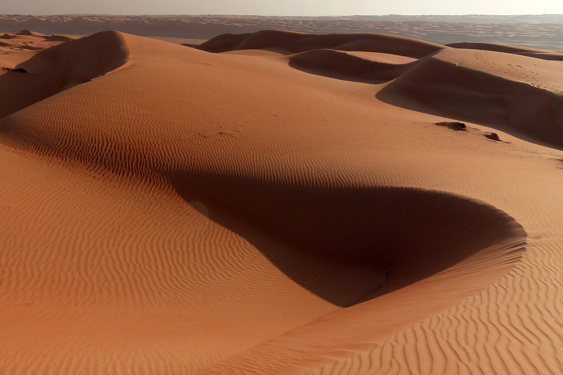 Dunes de sable baignées de soleil, évoquant un voyage sensoriel
